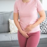 Menstrual pain, woman with stomachache suffering from pms at home, endometriosis, cystitis and other diseases of the urinary system - stock photo