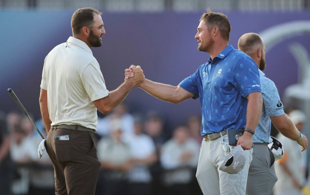 Scottie Scheffler of the United States and Bryson DeChambeau of the United States shake hands after finishing their round on the 18th green
