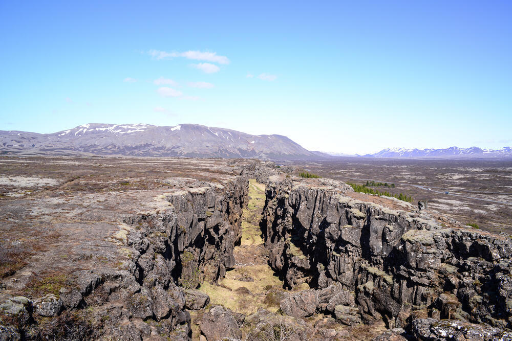 Iceland sits directly along the boundary between the North American and Eurasian tectonic plates, where the plates are pulling apart and forming new oceanic crust. The basalt rocks on both sides of the rift were formed by cooling lava (Photo: Lex0077/Shutterstock) איסלנד יושבת בדיוק על קו התפר שבין הלוח הטקטוני הצפון-אמריקאי והלוח האירו-אסייתי, שם שני הלוחות הטקטונים נפרדו זה מזה ויצרו קרום אוקייני חדש. סלעי הבזלת משני צדי הבקע הם תוצר של התקררות לבה