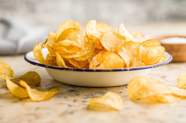 Crispy Potato Chips in bowl on a kitchen table