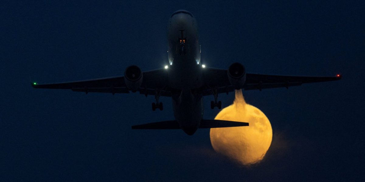 A commercial aircraft takes off during the start of a blood-red lunar eclipse as the moon rises in San Diego, California, U.S., August 27, 2026. REUTERS/Mike Blake TPX IMAGES OF THE DAY