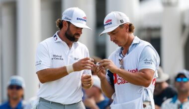 Cameron Young and his caddie look at a golf ball