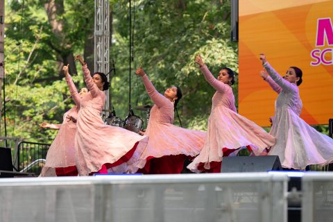 A group of dancers performs a traditional cultural dance on stage
