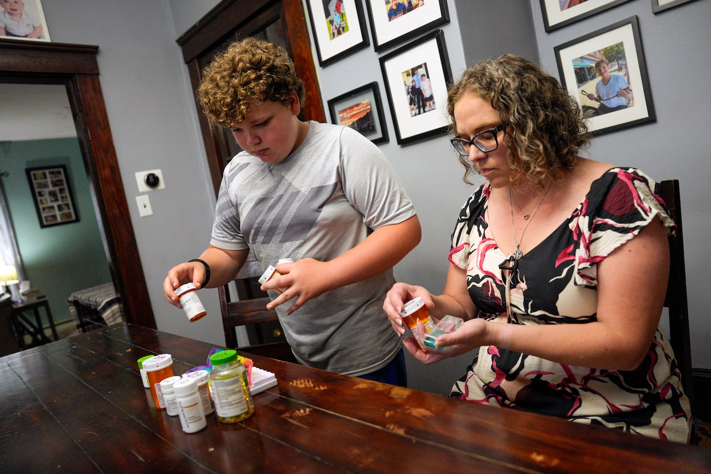 Martha Jean “MJ” Gouveia her son Sam, 13, organized medications for an upcoming trip to New Hampshire.