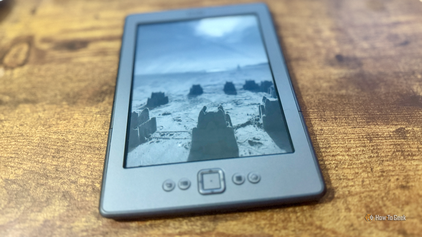 A Kindle 4 displaying a beach photo as the screen saver.