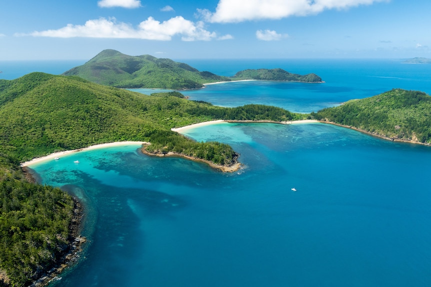 A green island, seen from the air, surrounded by water.