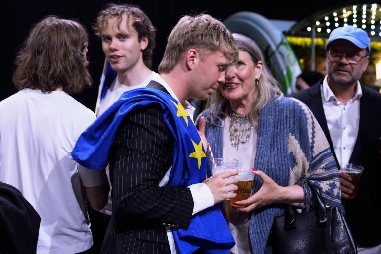 A supporter wearing a European Union flag attends an election-night gathering in Reykjavik, Iceland, Sunday, Aug. 30, 2026. (AP Photo/Marco Di Marco)