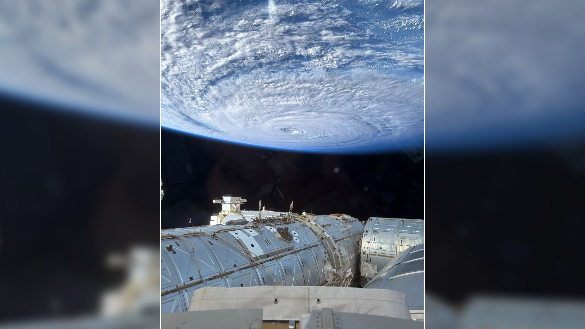a white swirl of cloud above blue ocean waters as seen from space