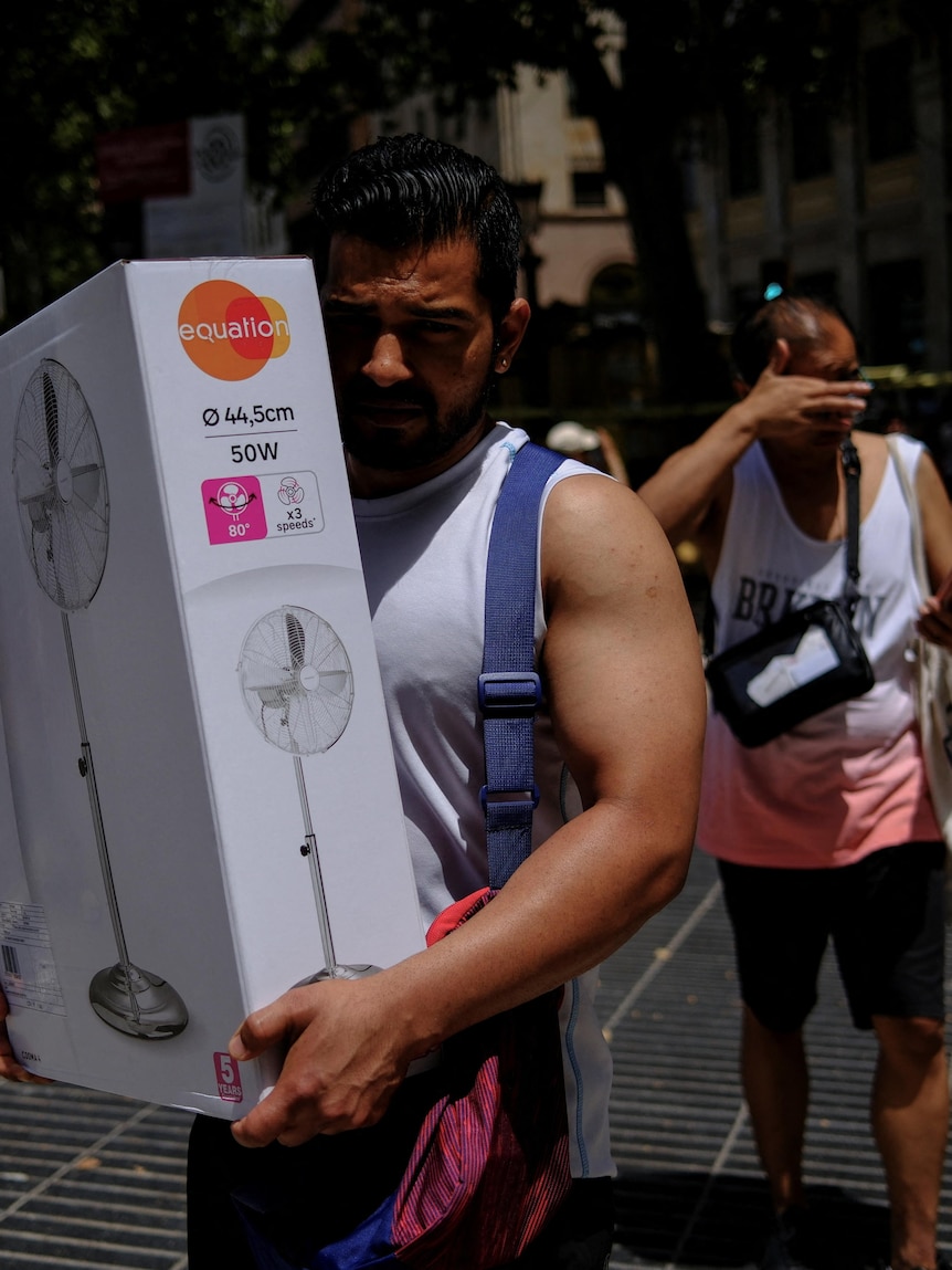 A man carries a newly purchased fan 