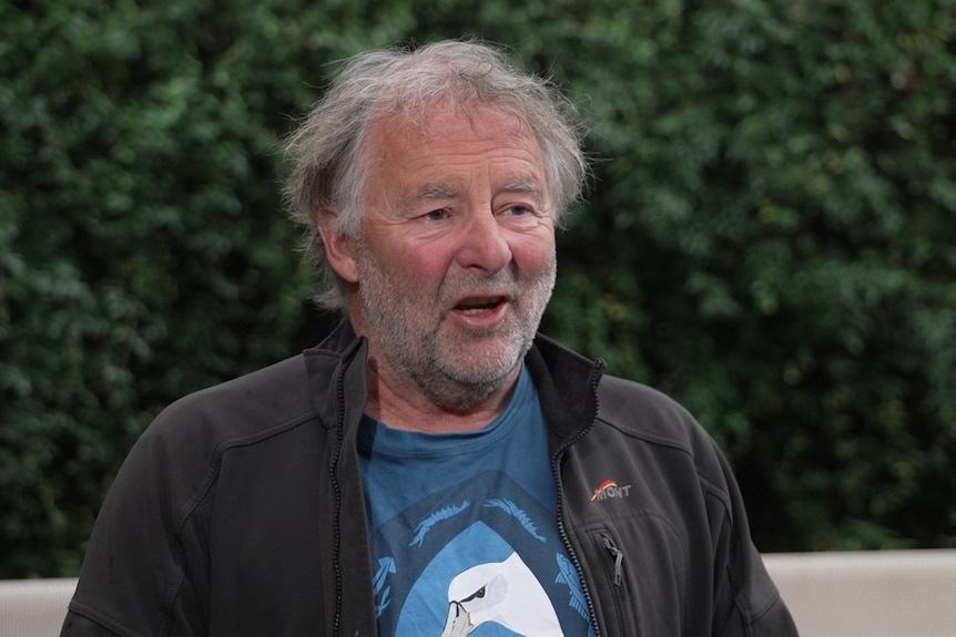 A middle aged man talks to reporter off screen.