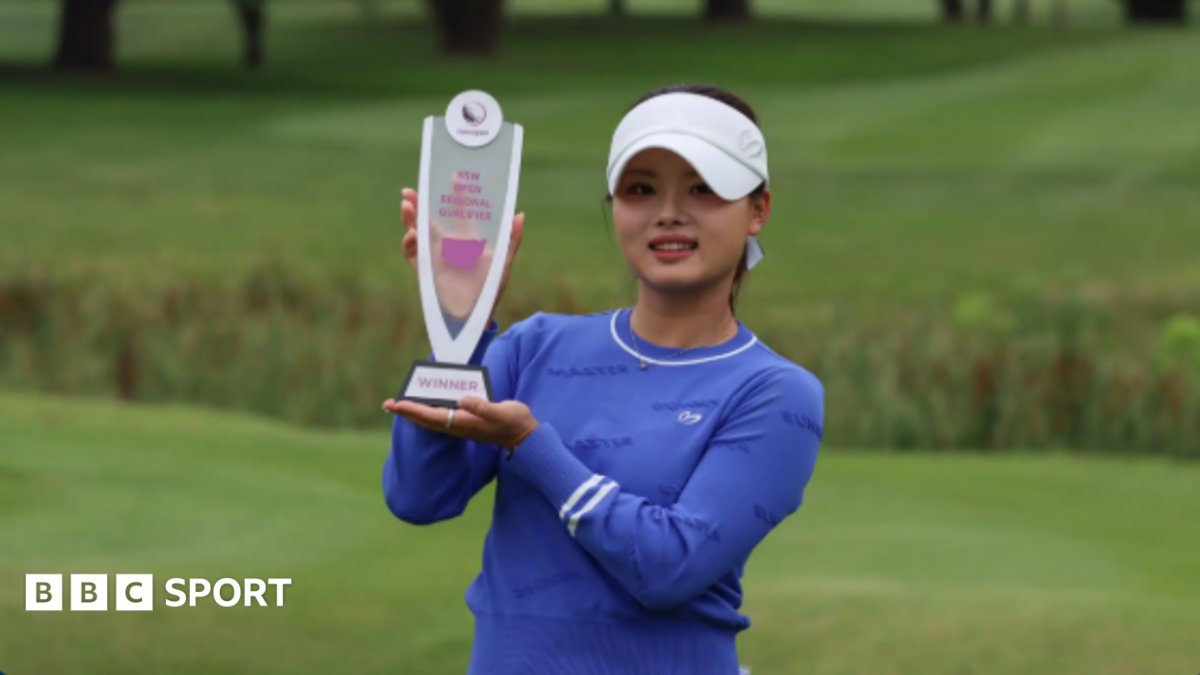 Jessica Bang posing for photographs on a golf course while holding a trophy
