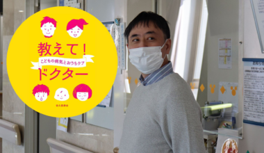 A man in a sweater wearing a face mask looks to the right of the camera.