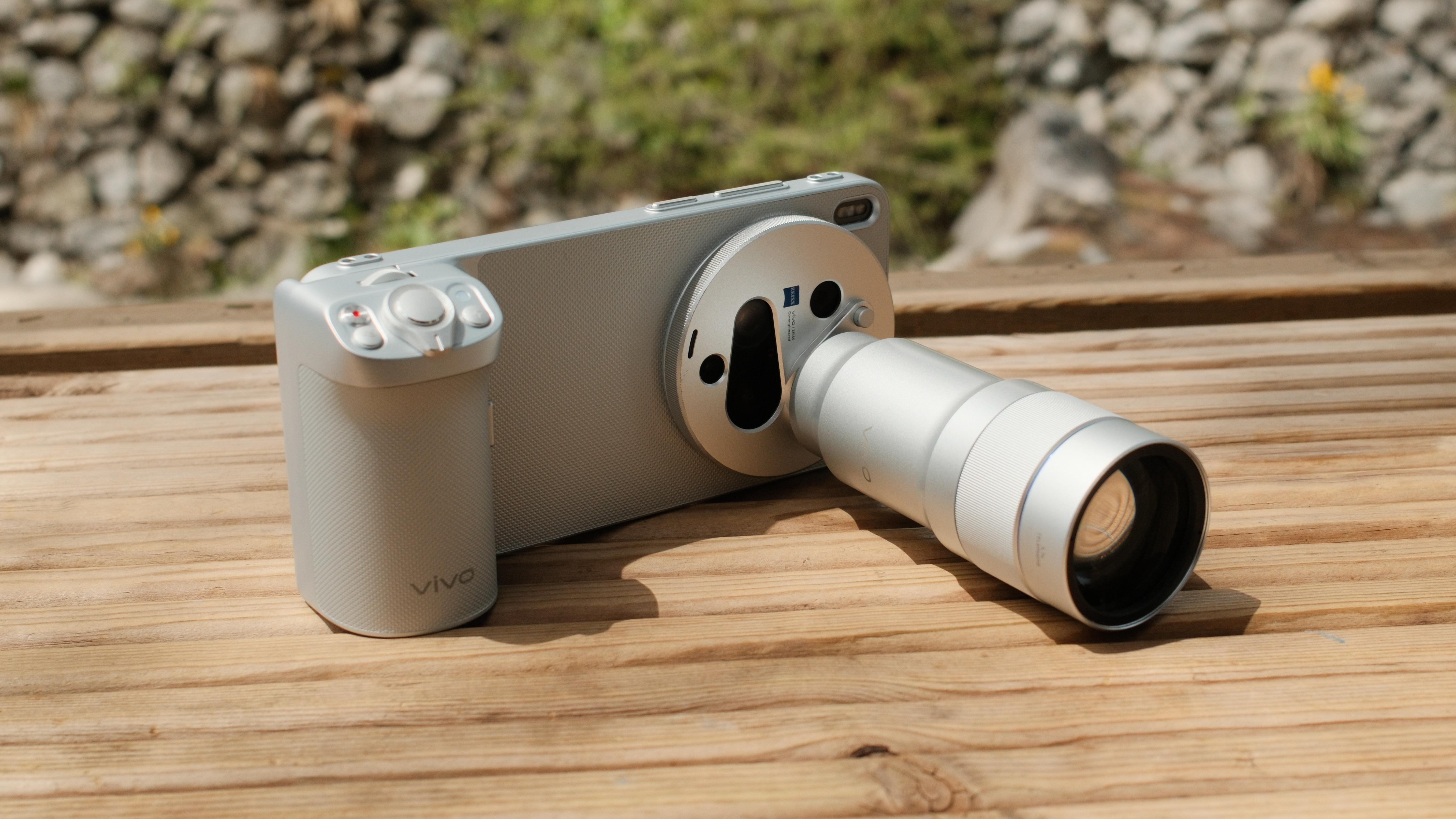 Vivo X300 Ultra in a camera grip case with a telephoto lens attachment