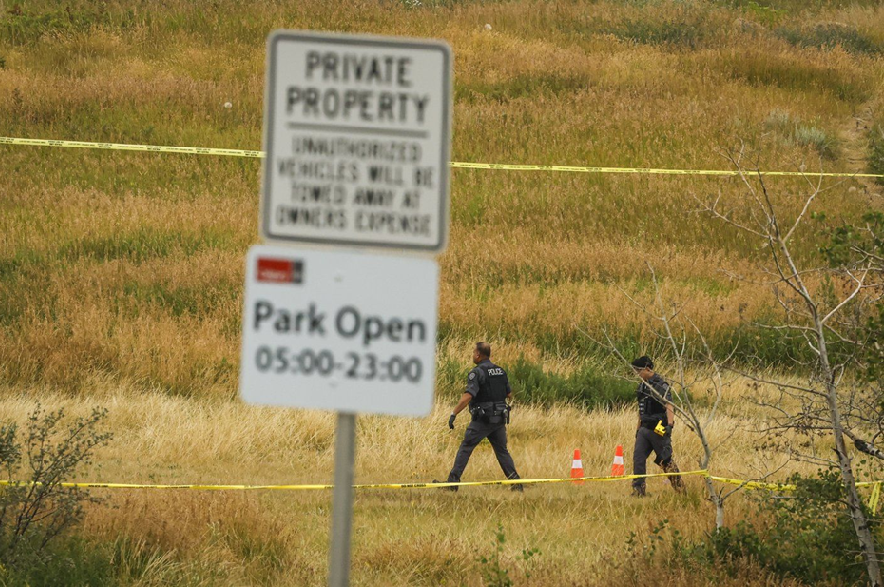 Calgary police officers look for evidence at the scene of an officer-involved shooting that took place near Edworthy Park in Calgary on Monday, Aug. 10, 2026.
