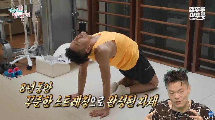 Singer Park Jin-young demonstrates a stretch using wall bars on MBC’s 'Omniscient Interfering View.' Courtesy of MBC