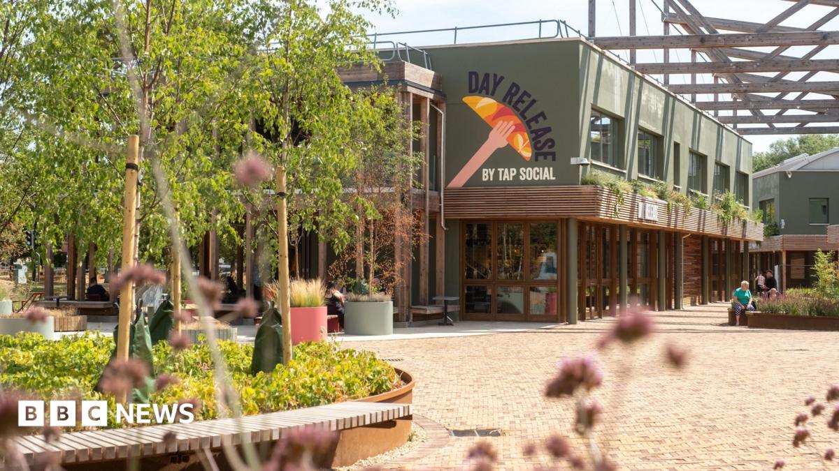 An exterior view of Tap Social's Day Release at Milton Park's Signal Yard. Some people are seating on benches in front.
