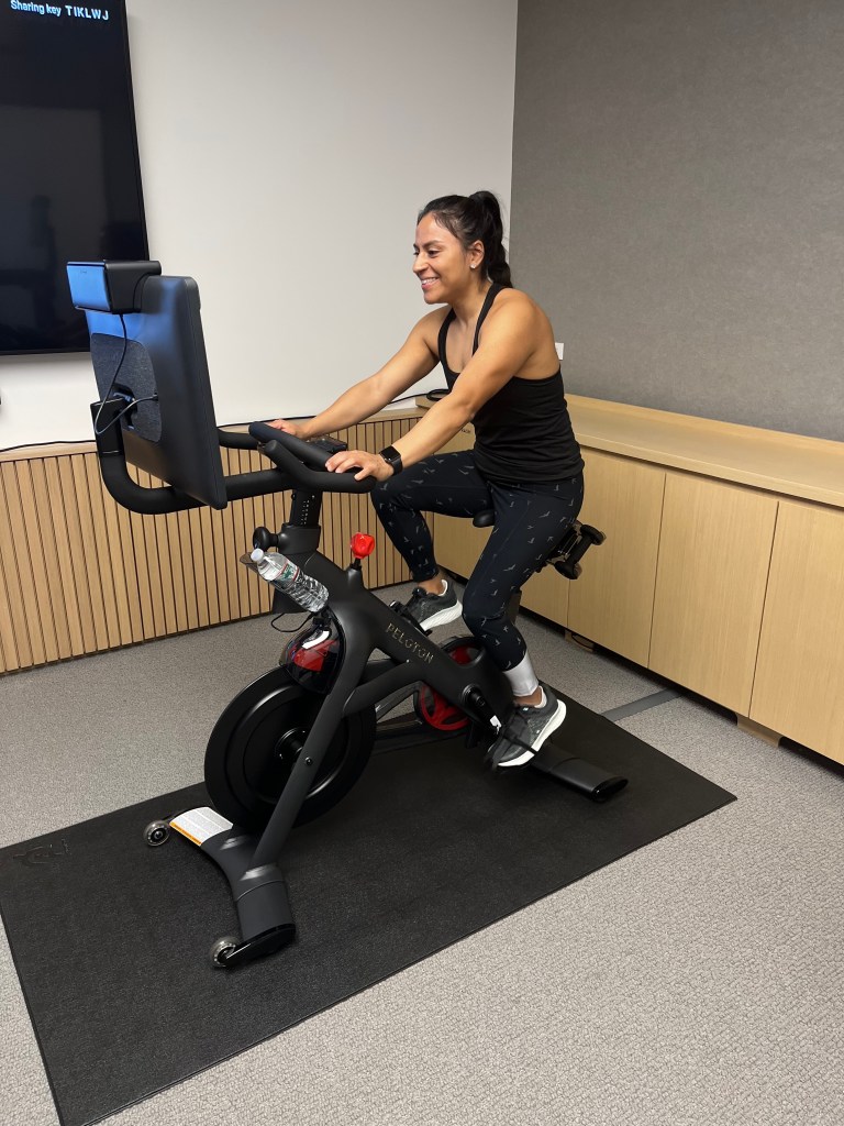 Woman riding the Peloton cross training bike plus