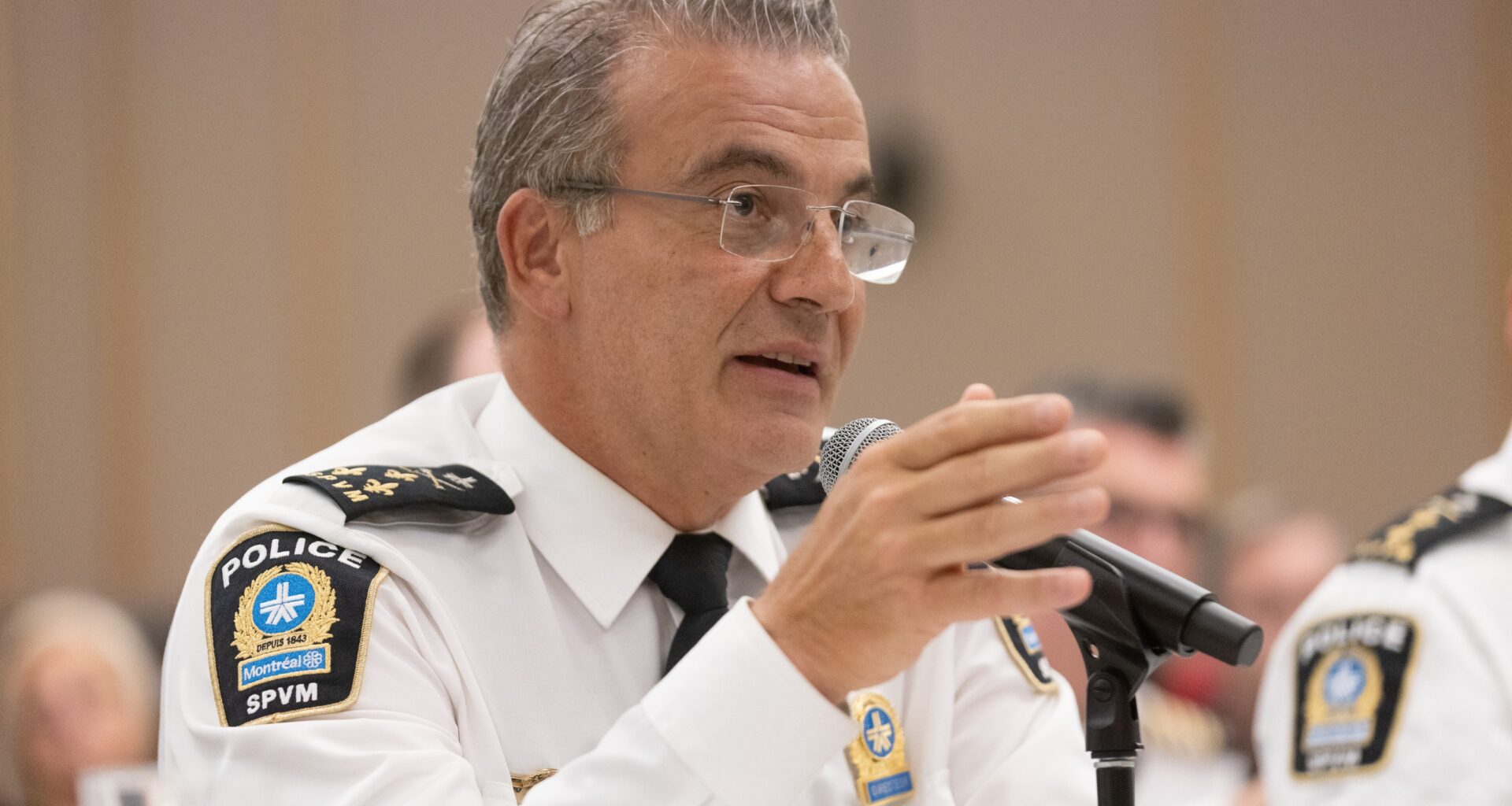 Man sits at table speaking into a microphone.