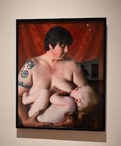 A photograph of a portrait of a woman breast-feeding her baby.