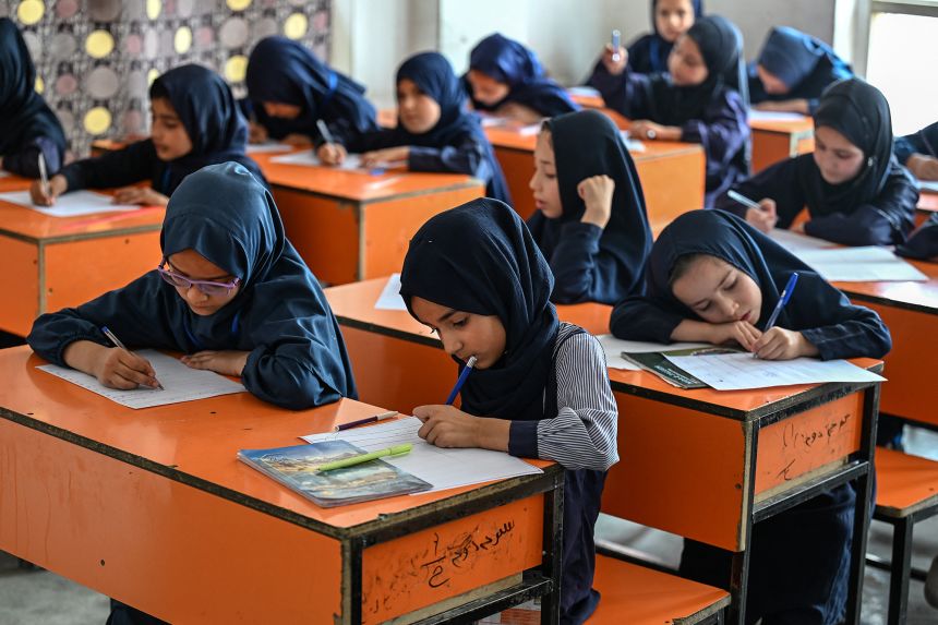 Afghan girls take their exams at a primary school in Kabul in July. Girls are unable to study past the sixth grade -- typically around age 12 -- under Taliban rule.