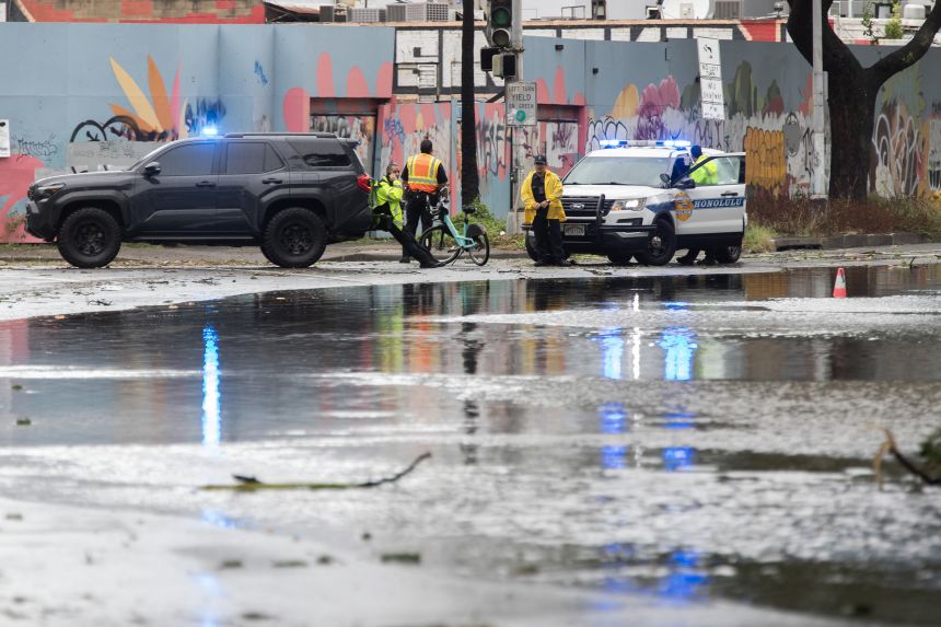 Police officers from the Honolulu Police Department block a flooded street near the Hawaii Convention Center in Honolulu, Hawaii, on August 16.