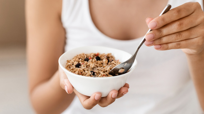 closeup of a woman holding a bowl of granola