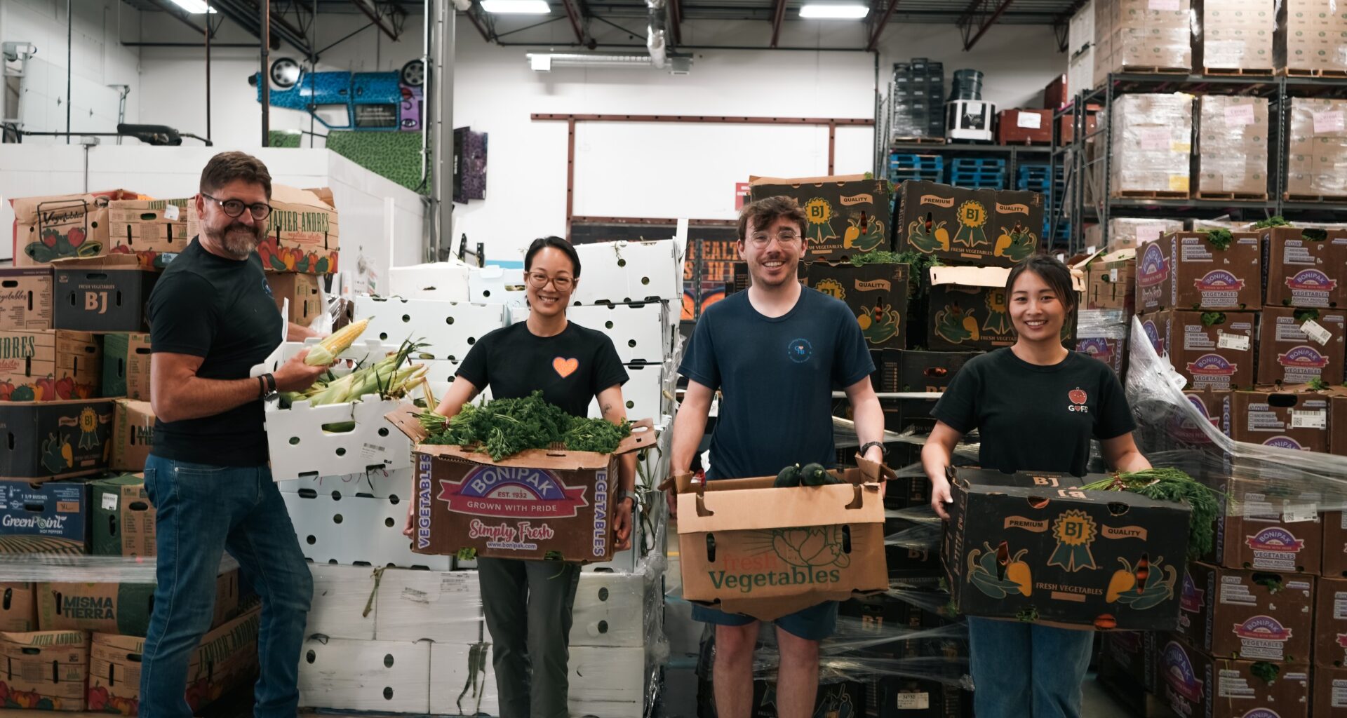 Regina Food Bank volunteers hold up produce from B.C. food bank