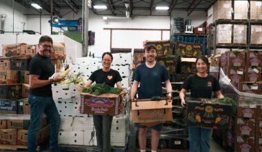 Regina Food Bank volunteers hold up produce from B.C. food bank