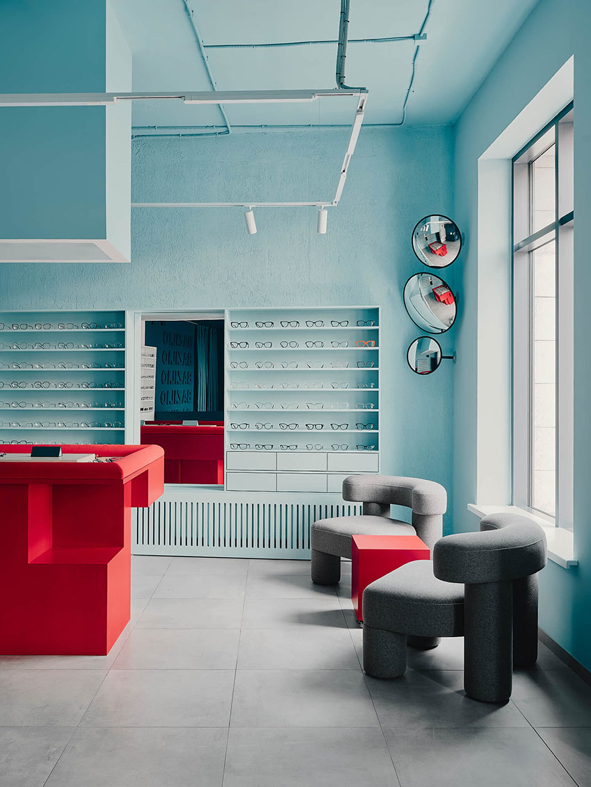 hubarch wraps an optics boutique in cold blue with single red interruption 2