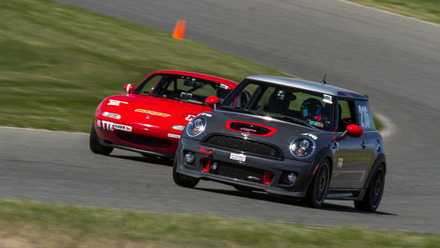 Mini Cooper and a Mazda Miata on a racetrack