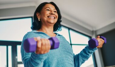 Woman smiling holding dumbbells
