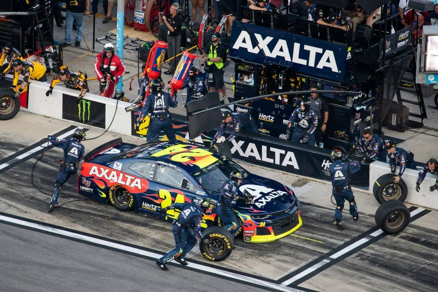 High-angle view of a NASCAR pit crew servicing the colorful number 24 stock car during a fast pit stop in pit lane. Photo by Andrew Roberts on Unsplash