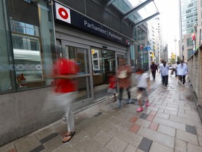 People walk past an OC Transpo station in downtown Ottawa.