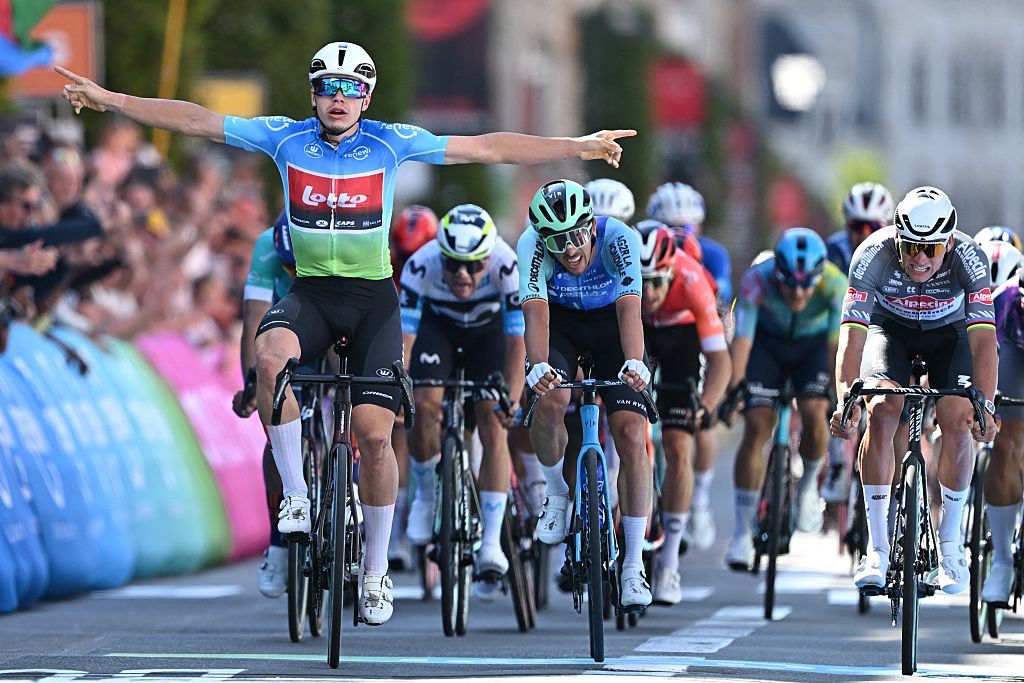 De Lie celebrating in the leader's jersey at the front of a bunch sprint