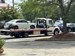 A damaged car on the bed of a tow truck.
