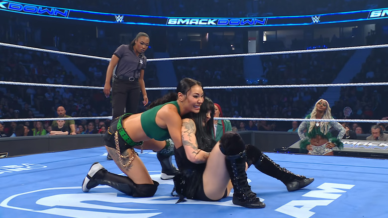 Michin wearing down Paxley with a submission hold inside the ring