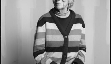 black and white photo of Mary Heilmann, sat in a striped cardigan