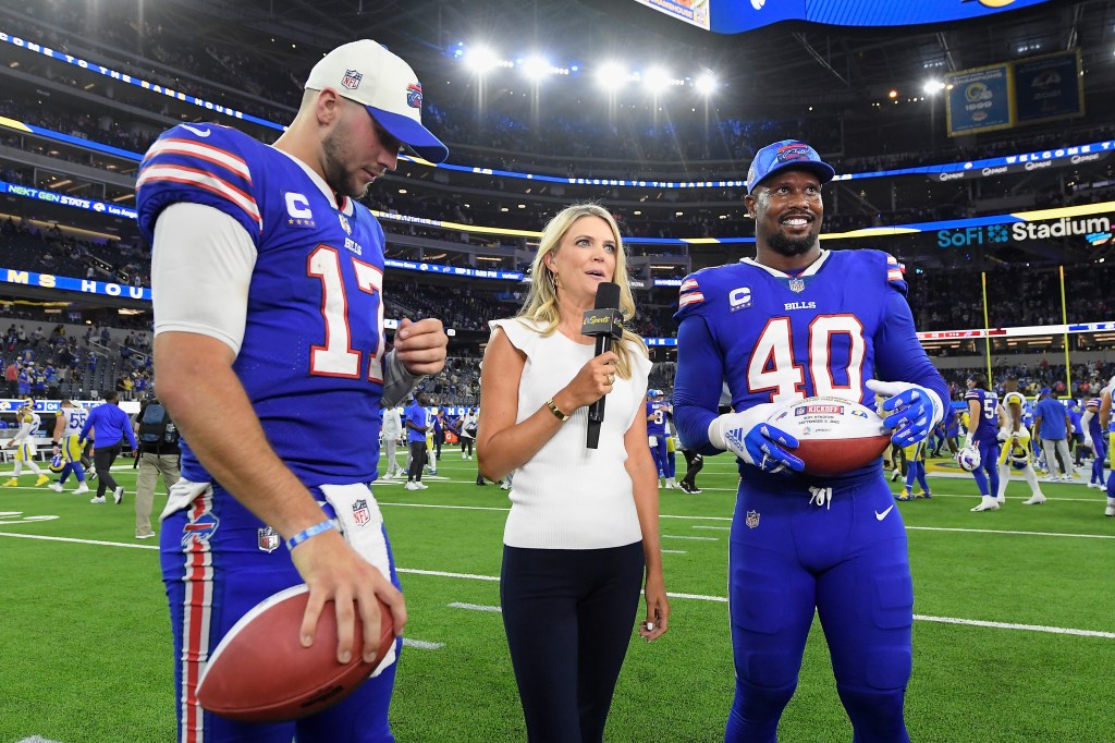 A female reporter interviewing Buffalo Bills players Josh Allen and Von Miller on the field.