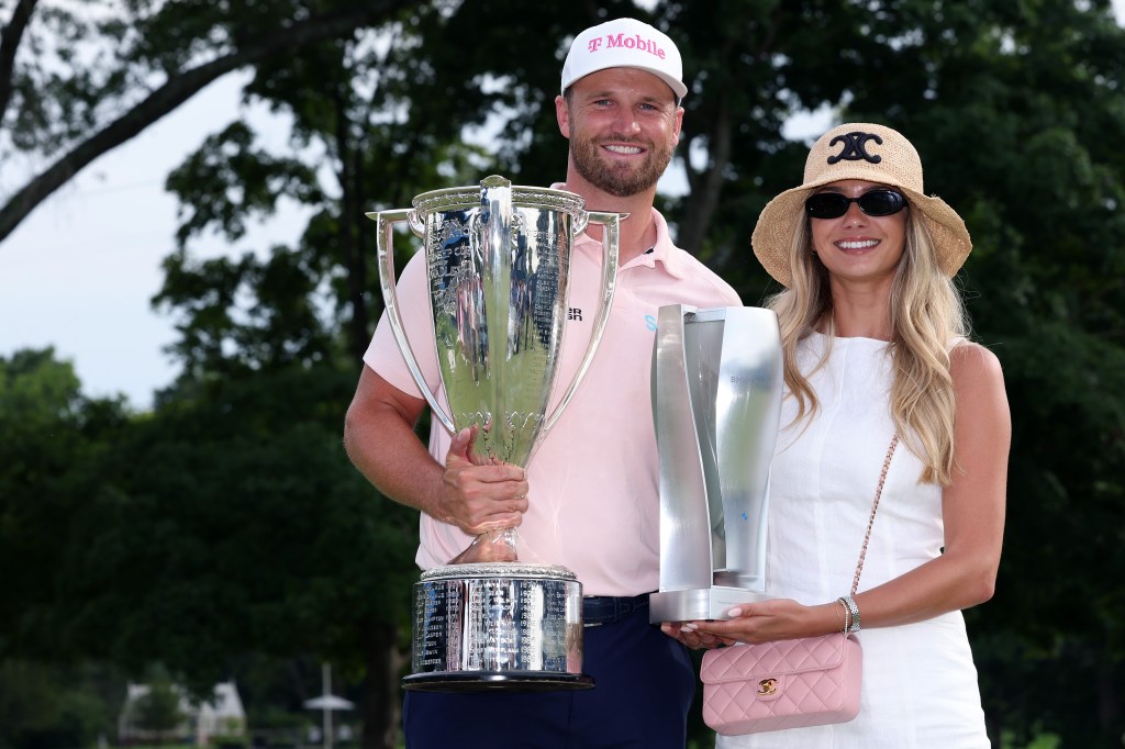 Wyndham Clark and girlfriend Emily Tanner pose with the winner's trophy and J.K. Wadley trophy after winning the BMW Championship 2026 at Bellerive Country Club in St. Louis, Missouri, on Sunday, August 23, 2026.