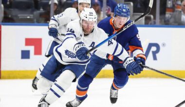 Apr 9, 2026; Elmont, New York, USA;  Toronto Maple Leafs defenseman Morgan Rielly (44) vies for the puck against New York Islanders right wing Simon Holmstrom (92) in the second period at UBS Arena. Mandatory Credit: Wendell Cruz-Imagn Images