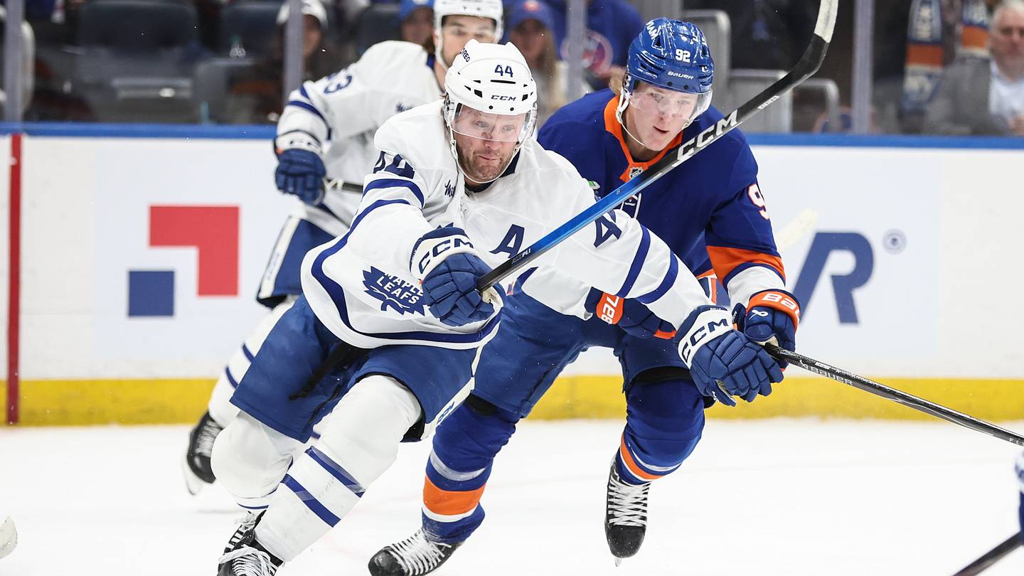 Apr 9, 2026; Elmont, New York, USA;  Toronto Maple Leafs defenseman Morgan Rielly (44) vies for the puck against New York Islanders right wing Simon Holmstrom (92) in the second period at UBS Arena. Mandatory Credit: Wendell Cruz-Imagn Images