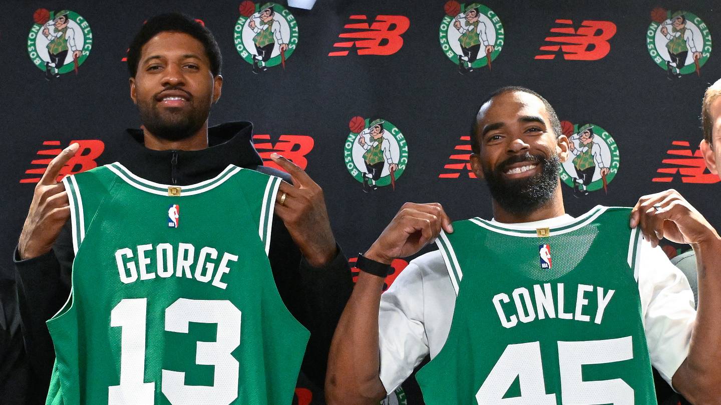 September 15, 2026; Boston, Massachusetts, USA; Boston Celtics forward Paul George (13) and Boston Celtics guard Mike Conley (45) pose with their jerseys after a press conference at The Auerbach Center at Boston Landing. Mandatory Credit: Eric Canha-Imagn Images