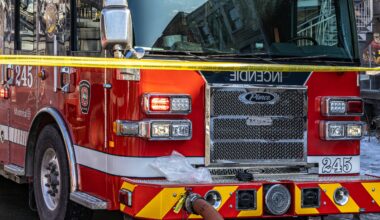 The front of a fire truck, with police tape across the front of it.