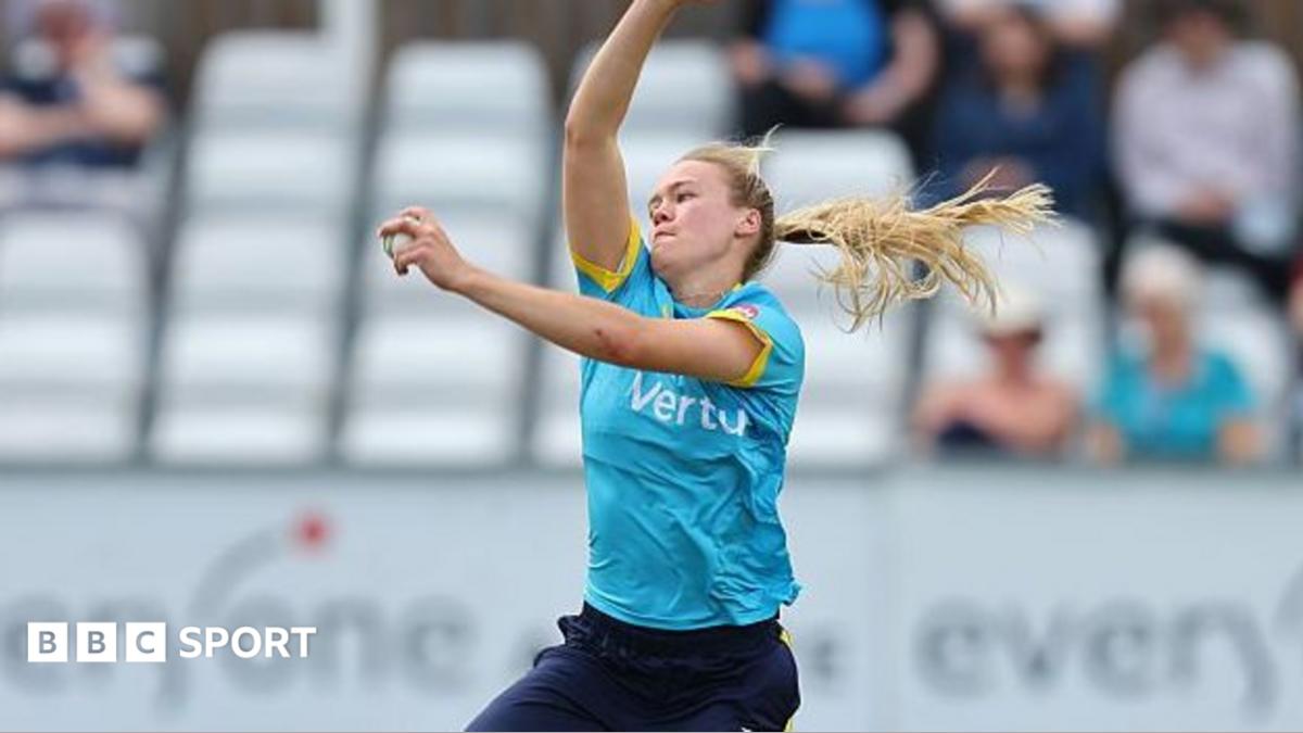 Alexa Stonehouse in sky blue shirt and navy blue trousers bowls for Warwickshire