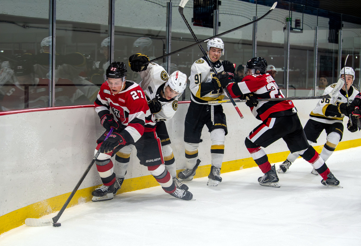 Hockey player escapes a melee against the boards