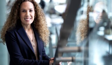 A woman poses in an out-of-focus office environment
