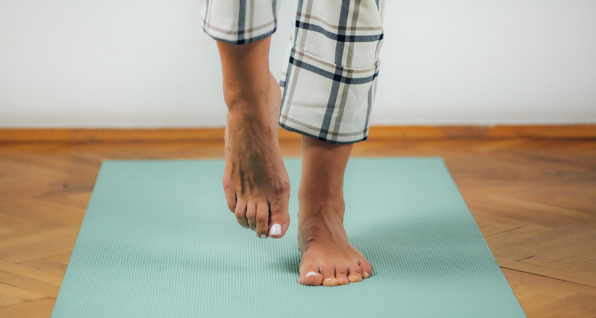 Person, shown only from the knees down, stands on one leg.