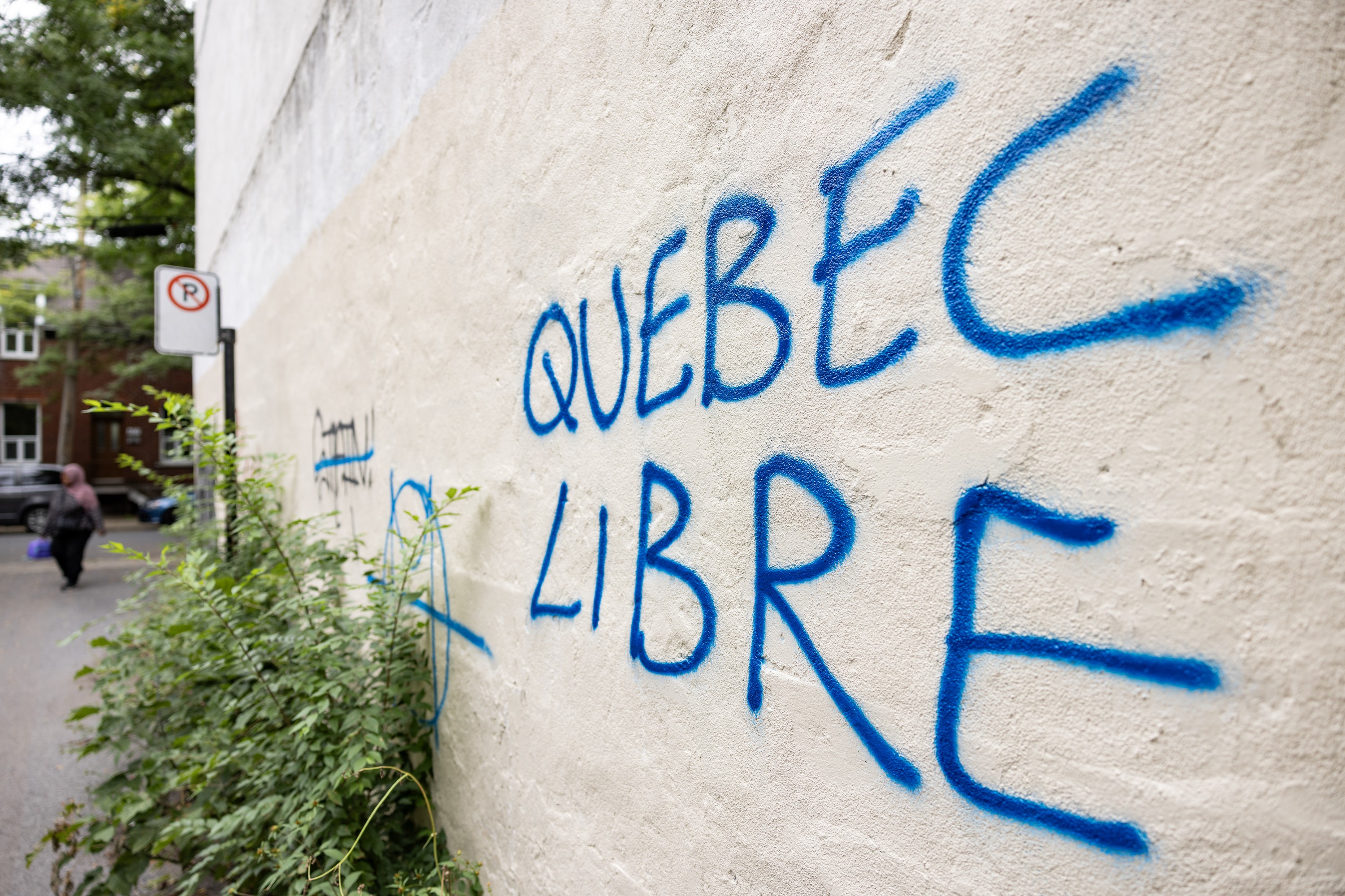 Grafitti on a beige outdoor wall says Quebec Libre