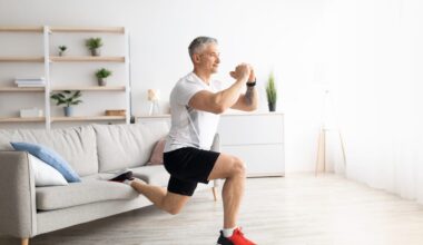 Active mature man doing squats while training at home, doing exercises near sofa in living room interior, keeping fit during covid-19 quarantine, empty space