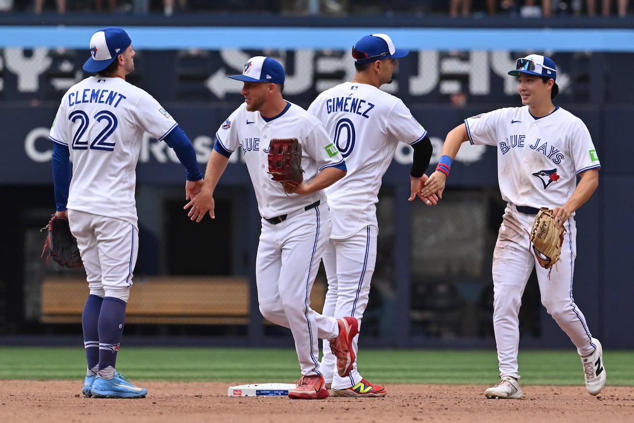Toronto Blue Jays players (left to right) Ernie Clement, Myles Straw, Andrés Giménez and Brett Bateman celebrate a win over the Seattle Mariners at the Rogers Centre.